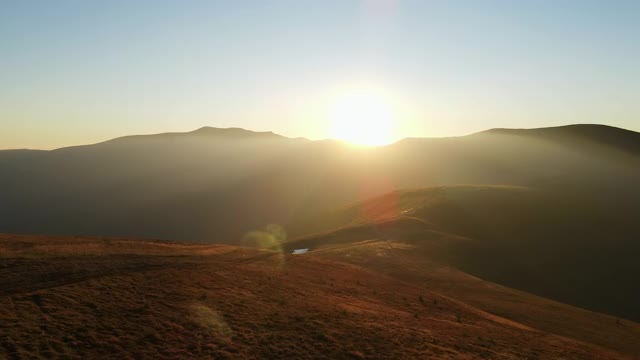 山脉剪影日落鸟瞰图。风景阳光多山概述。阳光透过云层在山中照射出来视频素材