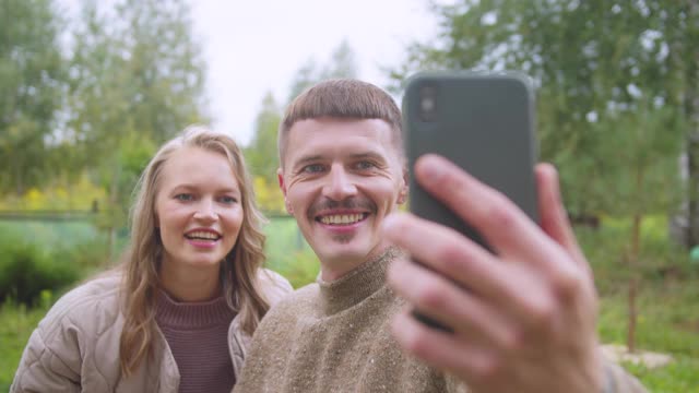 一对年轻夫妇在instagram上写旅行故事，向他们的订阅者挥手，慢镜头视频素材