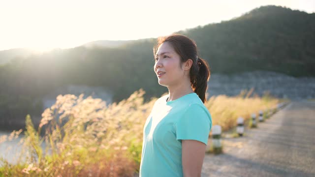 慢动作:女子在早晨结束锻炼后，通过跑步来放松视频素材