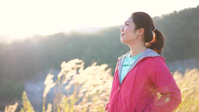 慢动作:女子在早晨结束锻炼后，通过跑步来放松视频素材