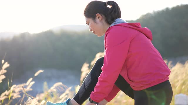 女人系着她的运动鞋准备在早上跑步时间视频素材