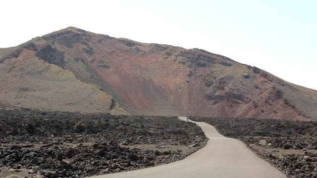 在提曼法亚国家公园，一辆白色汽车在阳光明媚的日子里驶近火山视频素材