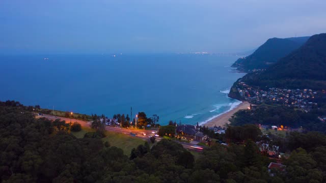 空中时间流逝潘:城市景观附近的山在黄昏海边-卧龙岗，澳大利亚视频素材