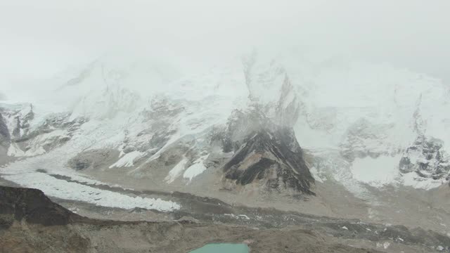 徒步旅行者在卡拉帕塔山顶观看昆布冰瀑，珠穆朗玛峰和Nuptse。尼泊尔的喜马拉雅山脉。鸟瞰图。无人驾驶飞机飞向后视频素材