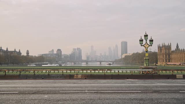 在新冠肺炎疫情期间，威斯敏斯特大桥封锁，伦敦街道安静、空旷、无人，高峰时段没有车辆，只有一人骑自行车视频素材