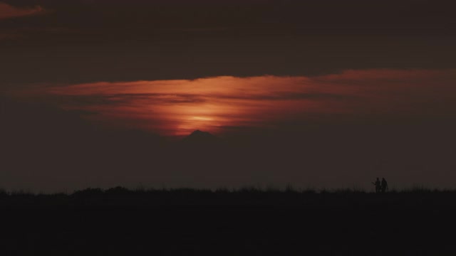 远处的人们在夕阳下的风景中行走的剪影/美国华盛顿库佩维尔视频素材