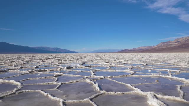 晴天的坏水盆地。有水和蓝天的盐壳形成。死亡谷国家公园。美国加州。鸟瞰图视频素材