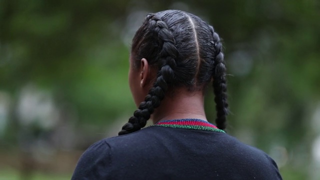 戏剧性的非洲女人站在外面盯着摄像机，追踪女孩的镜头视频素材