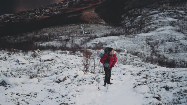 背包男子徒步攀登陡峭的雪山视频素材