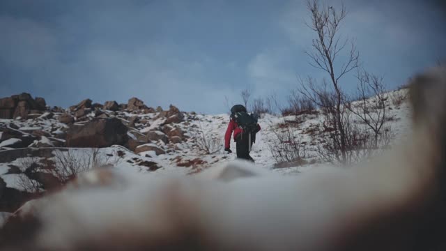 背着背包的男人在雪山上徒步旅行视频素材