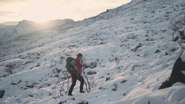 成熟的徒步旅行者背着背包在雪地里行走视频素材