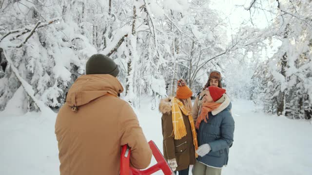 在冬季森林里玩雪橇的快乐朋友视频素材