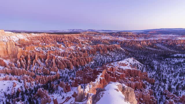 布莱斯峡谷hoodoo在冬天日出在阳光明媚的早晨。雪。布莱斯峡谷国家公园。美国犹他州。时间流逝视频素材