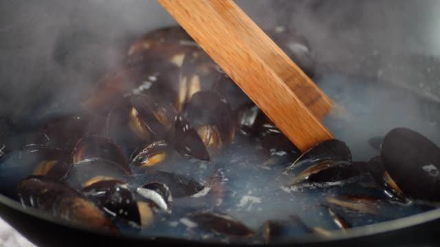 贻贝在炖锅里的沸水中搅拌。视频素材