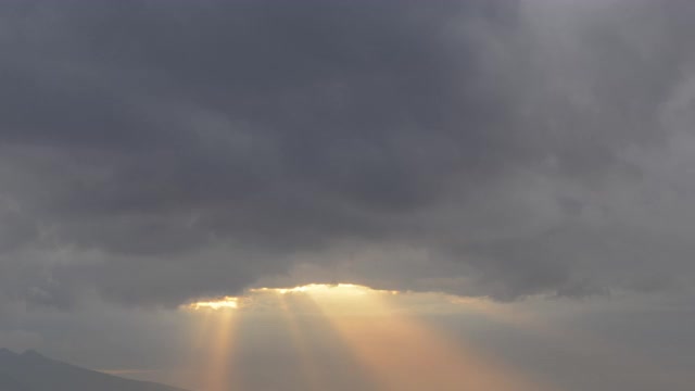 在黑暗的天空中，风暴云与阳光一起移动的视频时间流逝视频素材