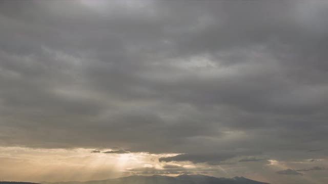 在黑暗的天空中，风暴云与阳光一起移动的视频时间流逝视频素材