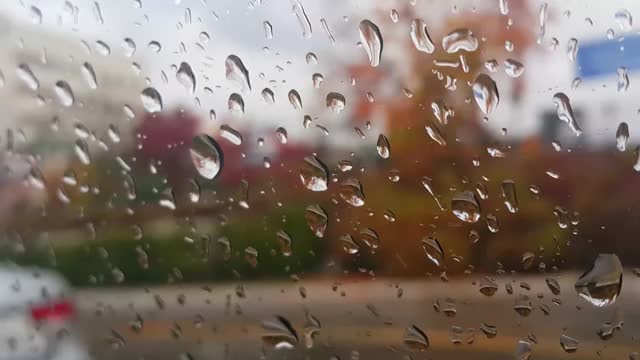 近距离观看雨滴对汽车玻璃模糊的看法视频素材