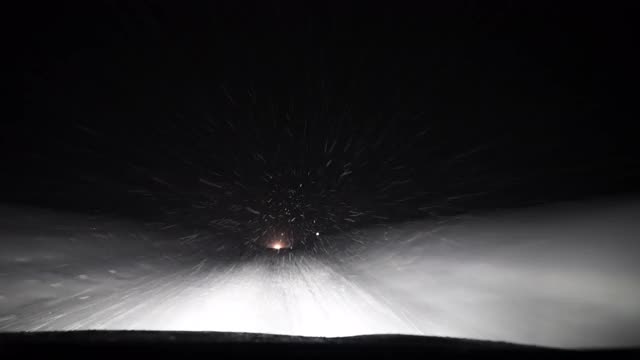 一辆汽车在夜间高速公路上穿过暴风雪的挡风玻璃视频素材