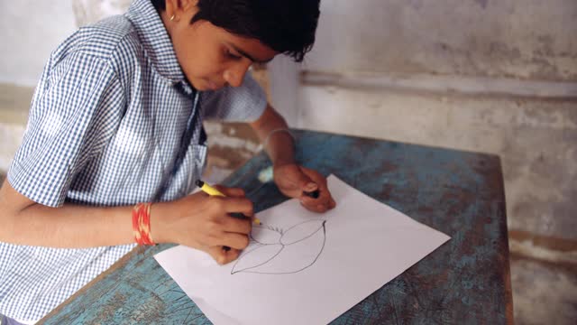 手持特写慢动作拍摄的一个男孩画的排灯节或Deepawali Diya-传统油灯来自印度次大陆，用于点亮传统节日的房子，根据印度教最大的庆祝活动视频素材