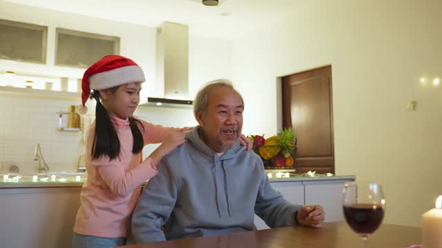 幸福的家庭时间和关系，亚洲大家庭有一个小聚会在家里吃食物。爷爷很高兴看到自己的孩子和侄子在饭桌上一起吃饭喝酒。视频素材