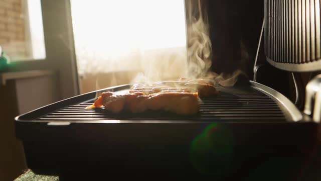 在电烤架上烹饪炸鸡肉。美丽的阳光在背景上。良好的营养。缓慢的运动。关闭了。视频素材