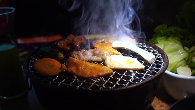 韩式烧烤，日式烧肉，特写。晚餐,新鲜。肉在木炭炉上烤。视频素材