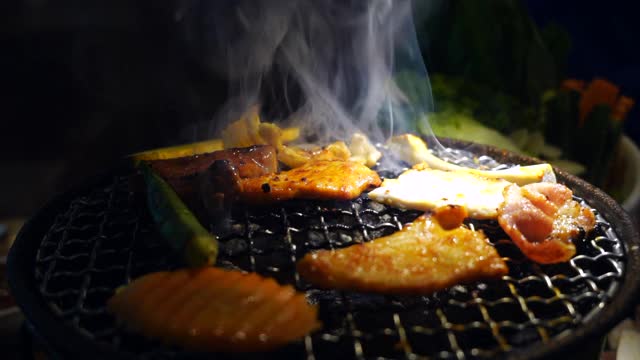 韩式烧烤，日式烧肉，特写。晚餐,新鲜。肉在木炭炉上烤。视频素材