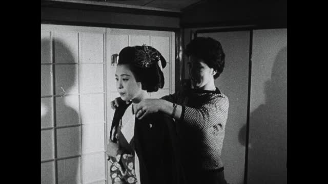 MS妇女帮助年轻的艺妓穿和服;1964视频素材