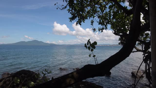 海景。白天的马来亚扬海滩与摩天大楼和山的背景在美那多市视频素材