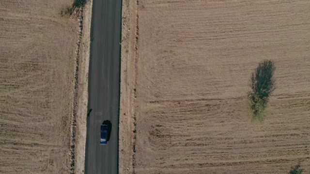 4K交通鸟瞰图蓝色汽车行驶在乡村道路上视频素材