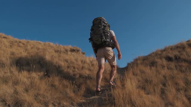 那个背着背包的人正在爬山。慢动作视频素材