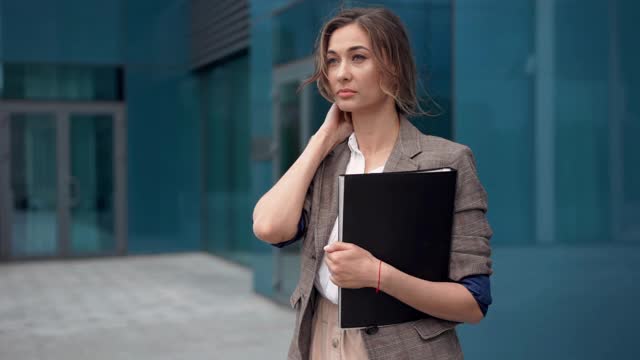 女商人成功的女商人站在户外公司大楼的外部。兴奋的白人自信职业女性中年视频素材