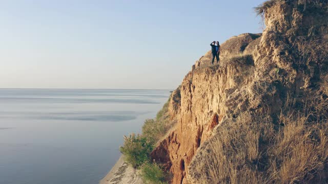 男人和女人站在海边的悬崖上视频素材