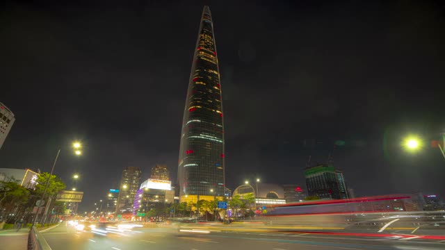 韩国首尔，松帕谷，Jamsil区，乐天世界大厦周围道路上的夜景和汽车运动视频素材