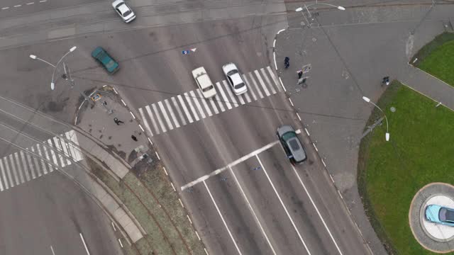 汽车通过人行横道附近的大十字路口，在城市上空无人机放大拍摄。视频素材