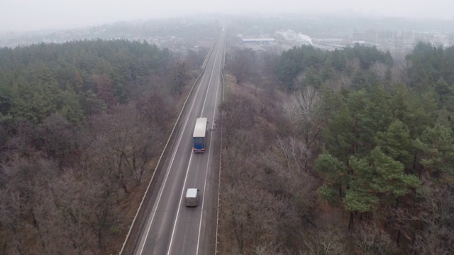 沿着乡村公路跟在一辆卡车拖车后面。视频素材