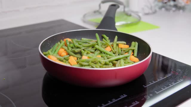 在煎锅里煮青豆和胡萝卜的特写。健康和健康的食物视频素材