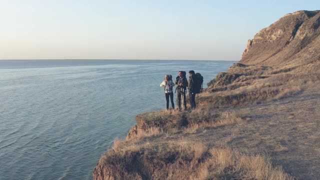 四个朋友站在沙滩上，以海景为背景视频素材