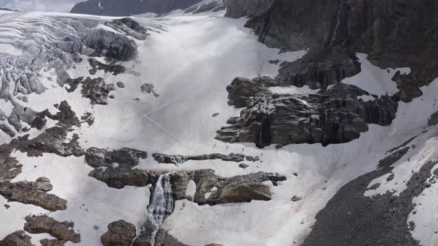 四名登山者从奥地利阿尔卑斯山脉的皮兹布因下山，融化奥克森塔尔冰川视频下载