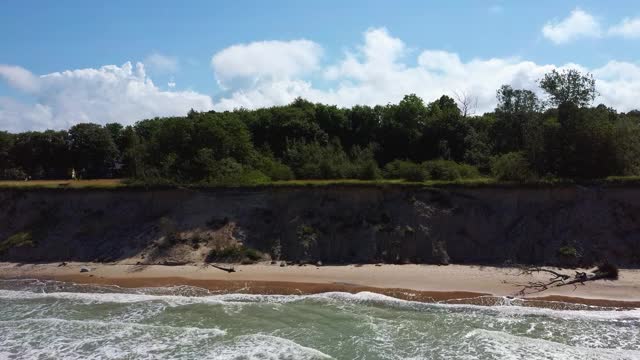 飞越海岸线波罗的海乌尔马莱海岸悬崖附近的Pavilosta，拉脱维亚和山体滑坡与一个杂草丛生的，波纹的洞穴点缀悬崖和鹅卵石。视频素材