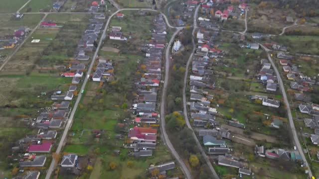 从高处鸟瞰美丽的乡村村庄，有房子和街道在犁地，草地视频素材