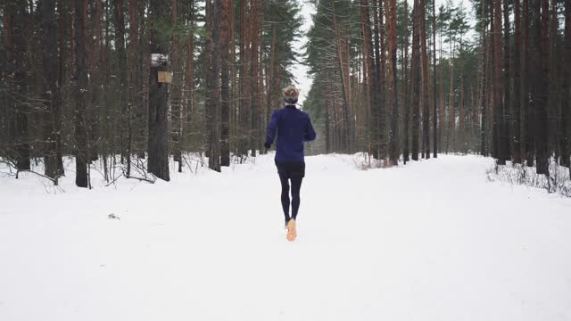 穿着运动服的跑步者在铁人三项前锻炼。冬季运动的概念视频素材