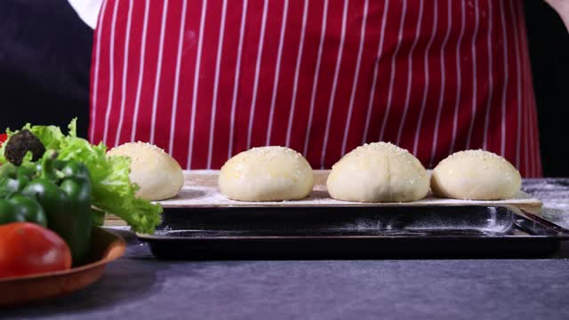 面包师准备生面团，在生面团上撒面粉，然后吠叫。手用面粉飞溅，食物自制烘焙概念视频素材