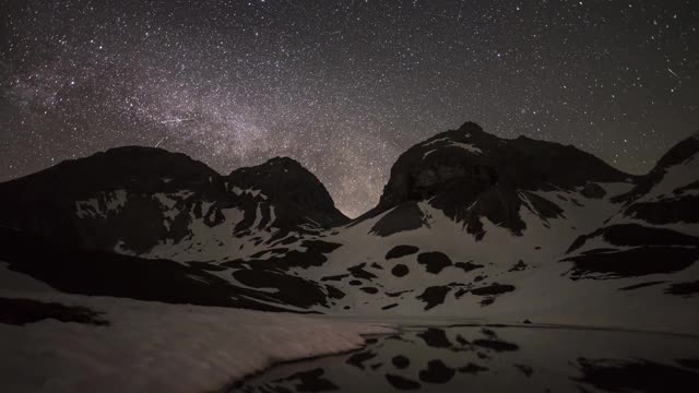 美丽的银河时光流逝在冰雪覆盖的艾尔高山脉和一个冰湖视频下载