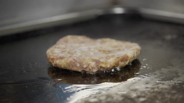 煮牛肉和猪肉肉饼做汉堡。肉在厨房烤。缓慢的运动。视频素材