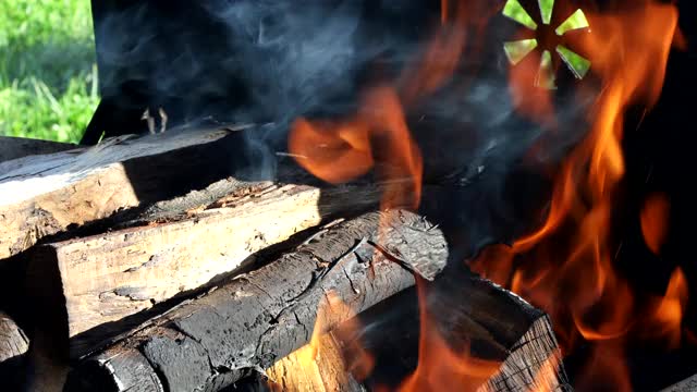 燃烧的木头，如在烤架上燃烧冒烟的木头的热余烬视频素材