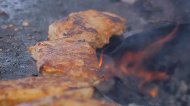 厨师用火钳在火盆上烤牛排:特写，慢动作视频素材