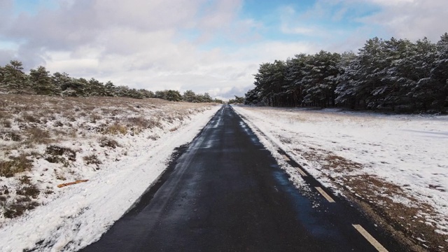 汽车在冰雪覆盖的雪山路上行驶。司机的观点。高质量4k镜头视频素材