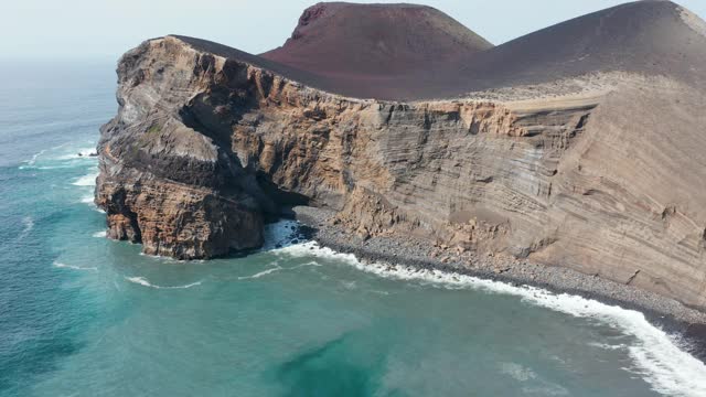 卡佩林霍斯火山的lauerered悬崖和岩石岩洞被蓝色的海洋包围。Faial,亚速尔群岛视频素材