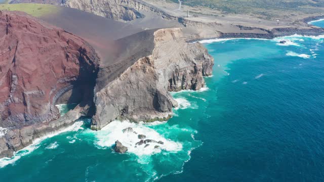 在岩石和荒凉的火山表面飞向绿树成林的山丘。亚速尔群岛法尔的空中飞机视频素材